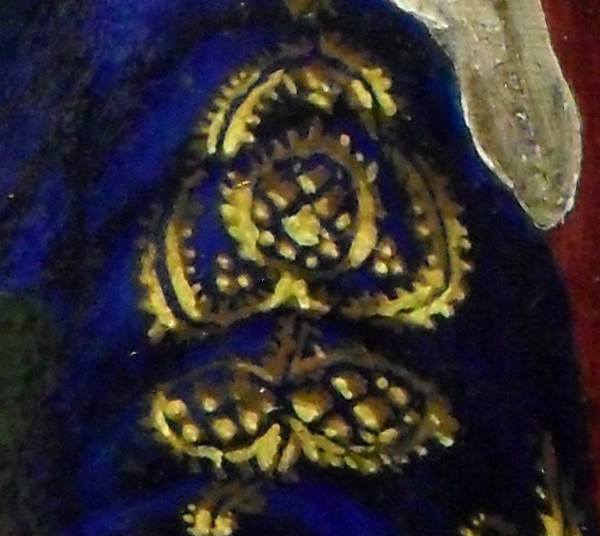Detail of the blue and gold brocade on the top of her left sleeve. As was often the case, the material that made the clothes was cut so that patterns were symmetrical. At the top, you can see the end of the fine linen headdress hanging down. Copyright (c)2016 Paul Alan Grosse