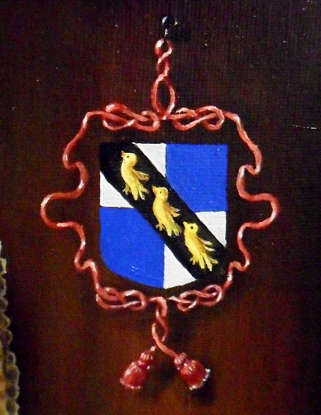 Close-up of the Grosse coat of arms - from the 'Roll of Arms of the Reign of Edward the Second'; 'Le Gros, quartile de argent e de azure, a une bende de sable e iij merelos de or' - quarters of silver and blue and a diagonal black band with three gold blackbirds. Copyright (c)2016 Paul Alan Grosse