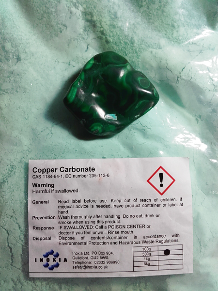 Powdered malachite - copper ore - and a piece of malachite. Copyright (c)2019 Paul Alan Grosse