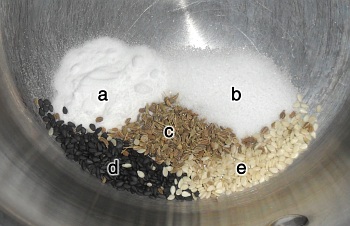 a) Sodium Bicarbonate, b) salt, c) anise seeds, d) black sesame seeds e) white sesame seeds.