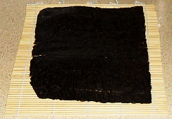 Place the sushi nori on the rolling mat.