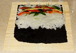 Arrange your sliced vegetables on the rice in a line.