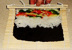 Roll over the sushi so that the vegetables are secured then continue rolling.